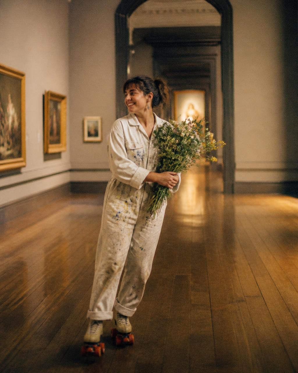 Woman roller skating through an art museum with wildflowers