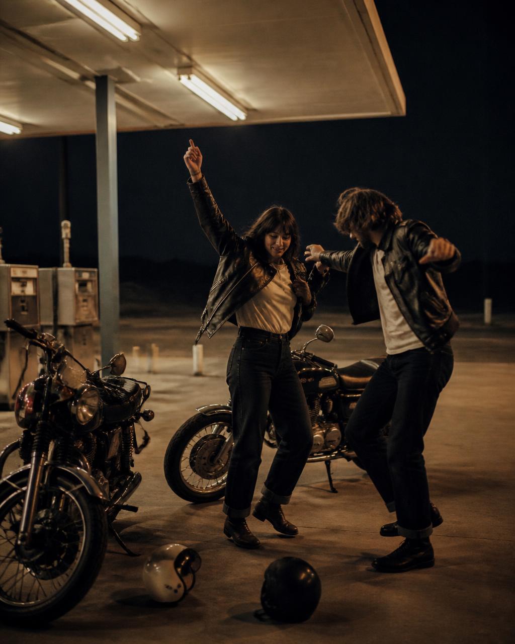 Friends dancing beside motorcycles at a desert gas station