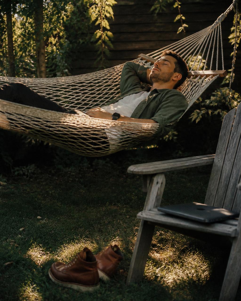 Man asleep in a hammock, work boots kicked off