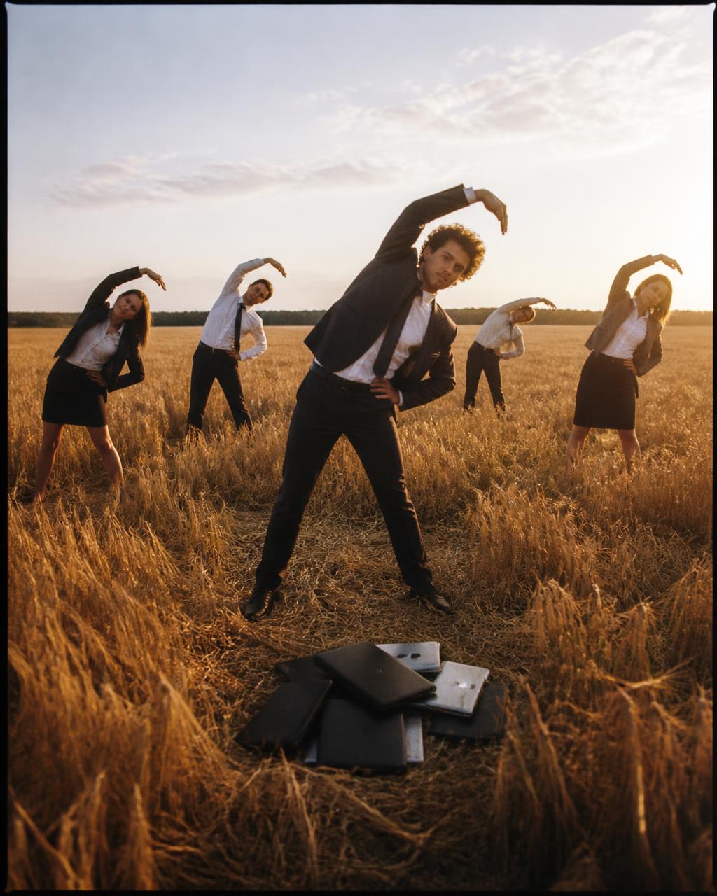 Business people doing morning stretches in a golden field