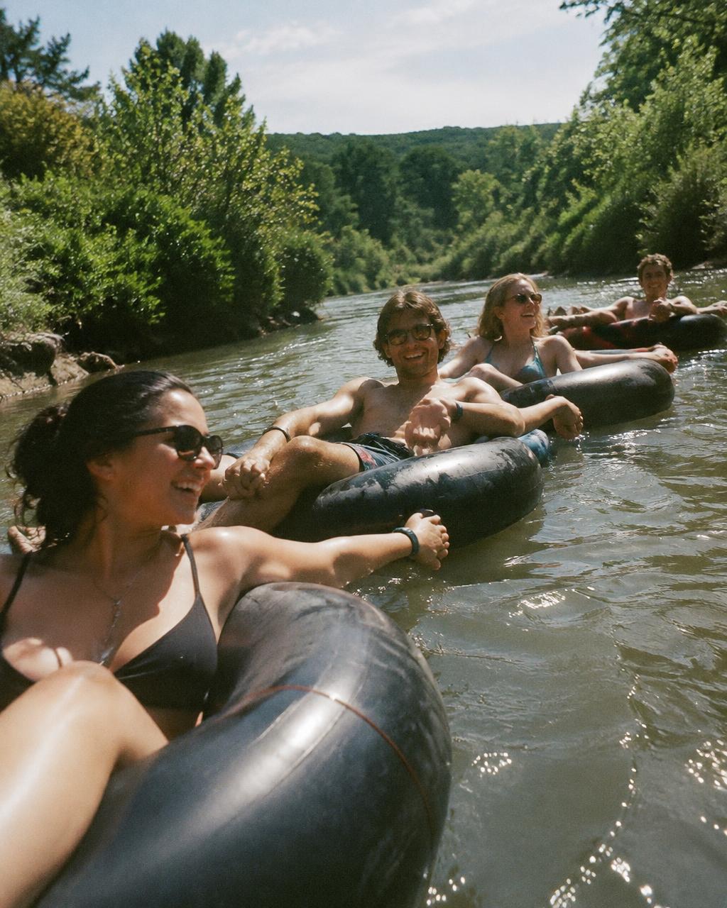 Friends floating down a lazy river holding hands